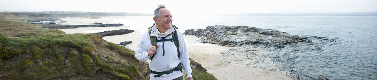 Retirement blog, smiling man hiking on coastal waters, June 2024, TCU