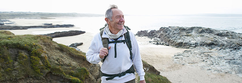Retirement blog, mobile view of smiling man hiking on coastal waters, June 2024, TCU