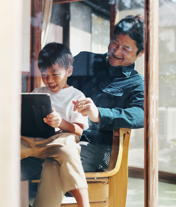 parent and child laughing at tablet screen