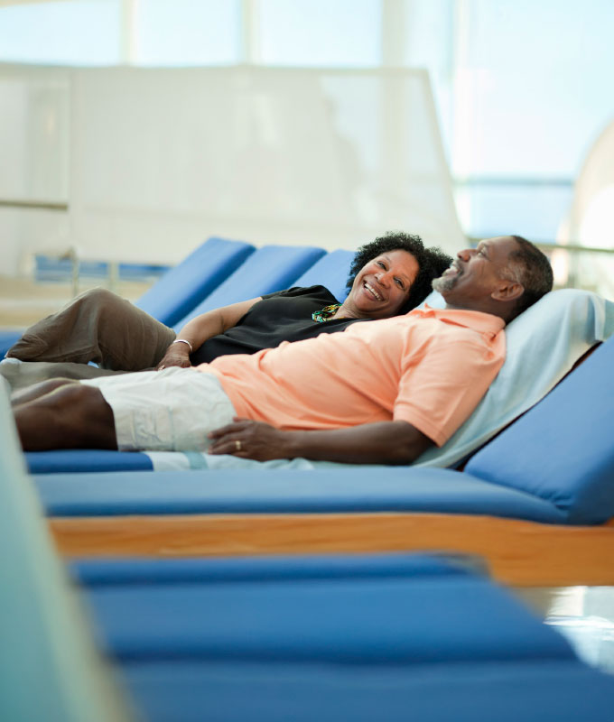 senior couple relaxing on lounge chairs outdoors