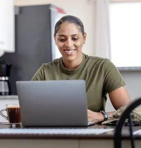 smiling military using a laptop with coffee